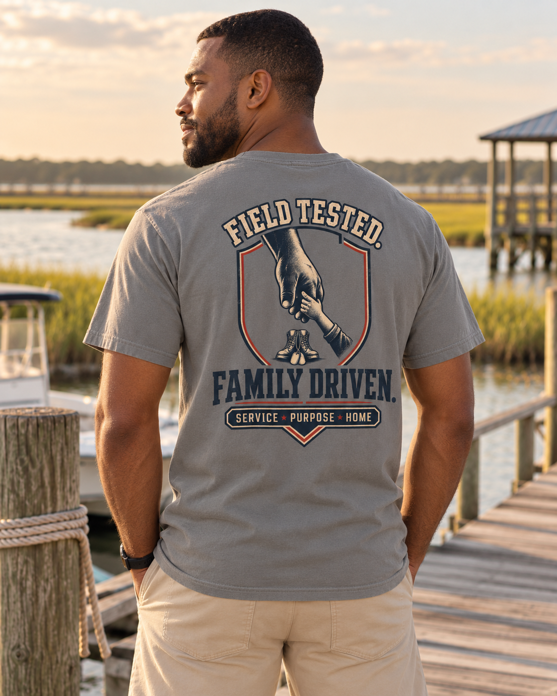 A man wearing a gray t-shirt with a large back graphic that reads 'FIELD TESTED. FAMILY DRIVEN.